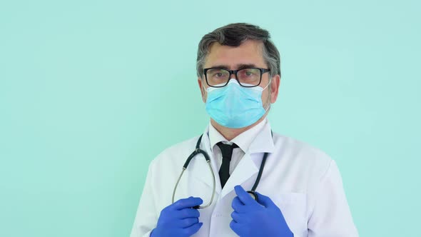 Portrait of a Senior Doctor in White Suit and Protective Mask on Blue Background