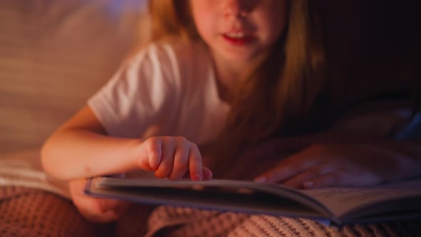 Child Reads Story Following Line with Finger Near Mother