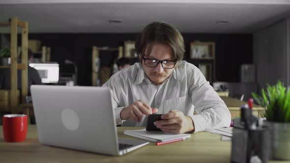 Young Businessman Is Working on Smartphone at the Office