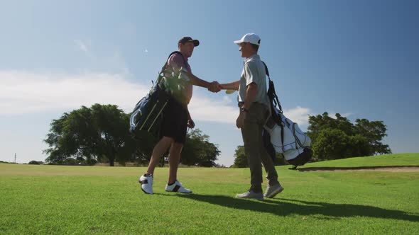 Caucasian male golfers standing on a golf course on a sunny day