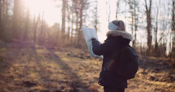 Tourist Reading Map on Trail in Mountains