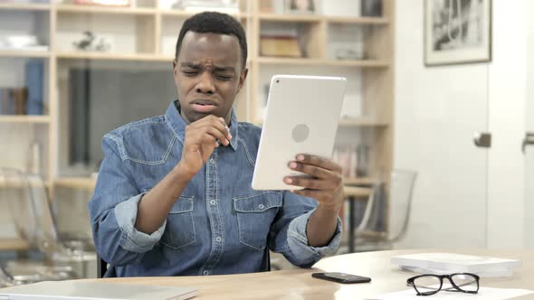 Afro-American Man Reacting to Loss while Using Tablet