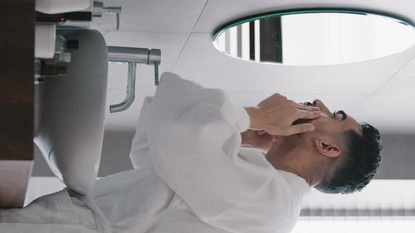 Vertical View Arabian Indian Arab Hispanic Bearded Man in Bathrobe Applying Moisturizer Cream on