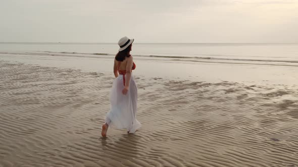 cheerful woman in bikini walking on the sea beach