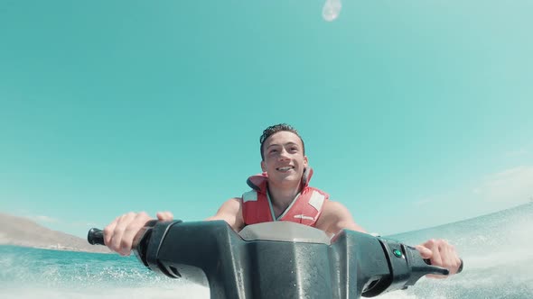 Teenager man enjoying summer in a jet ski in the middle of the sea having fun racing alone