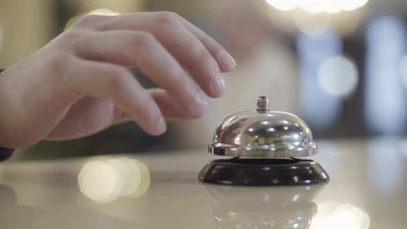 Extreme Close-up of Unknown Caucasian Man Pressing Hotel Bell