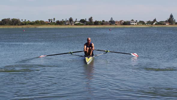 Senior caucasian man rowing boat on a river