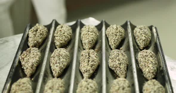 Baguette Tray With Dough Topped With Multigrain Seeds - Ready For Baking - close up shot