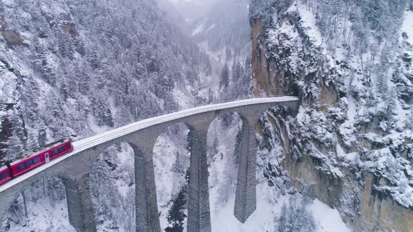 Landwasser Viaduct with Railway and Train at Winter Day. Snowing. Switzerland. Aerial View