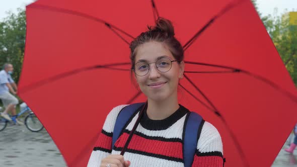 Girl Looking at Camera Twirling Red Umbrella