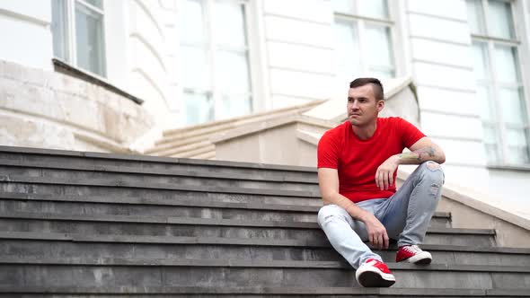 Male Tourist Sitting on Steps of Palace