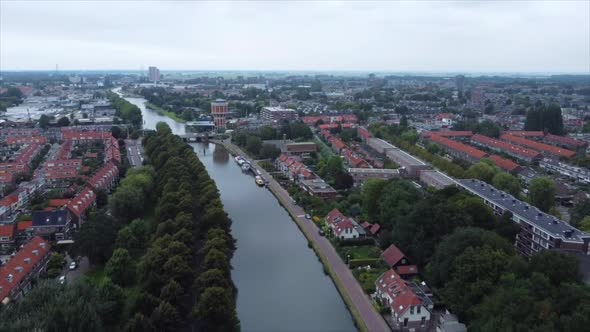 Aerial shot of boat on river flowing through city in the Netherlands