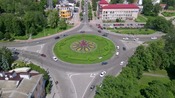 Aerial View of Roundabout Road with Circular Cars in Small European City at Sunny Day