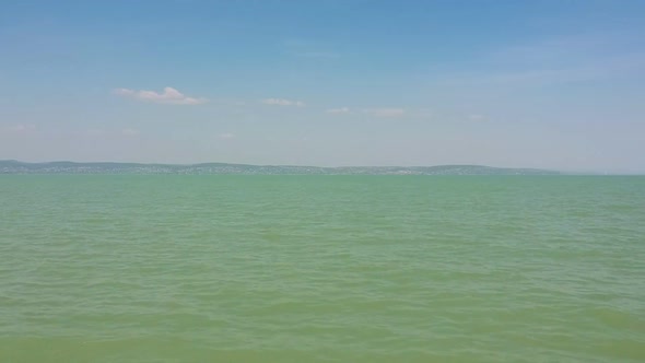 Afternoon upwarded drone view from the Lake Balaton's waves and its water roof near the shore of Zam