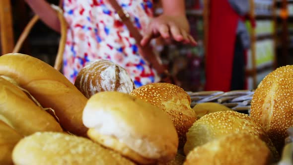 Mid section of woman selecting bread