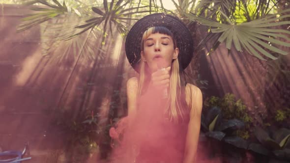 Young Charming Caucasian Woman with Pink Smoke Bomb Makes Sensual Movements