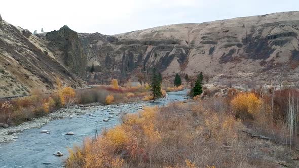 Ariel drone footage of a rugged river valley in fall.