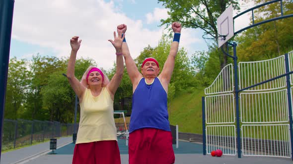 Active Elderly Sports Team Athletes Putting Arms Hands Together Cheering and Ready to Win Smiling