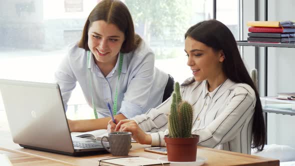 Female Designer and Her Assistant Working Together on the Laptop