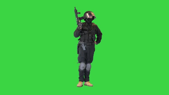 Policeman in Protective Cask with a Rifle Raised Up on a Green Screen Chroma Key