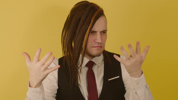 Pensive Male with Doubt Glance Counts on Fingers on Yellow Background