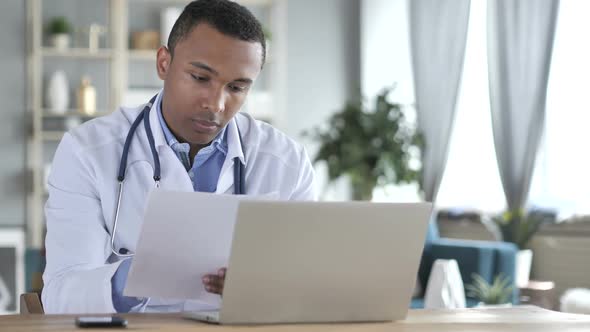 AfricanAmerican Doctor Reading Medical Report Diagnosing Patient