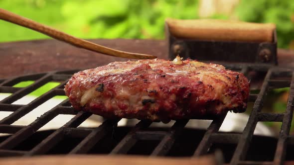 A Chief Is Checking Delicious Homemade Meat Cutlet for a Burger on the Grill