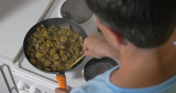 Man cooking stewed vegetables at home