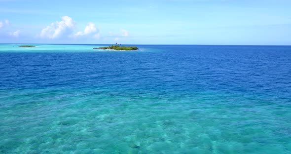 Natural fly over tourism shot of a white sand paradise beach and blue water background