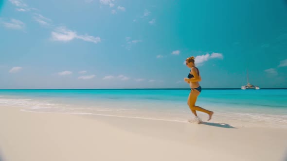 Girl running in surf and splashing water, Klein Curacao