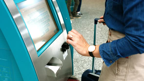 Female commuter using airline ticket machine