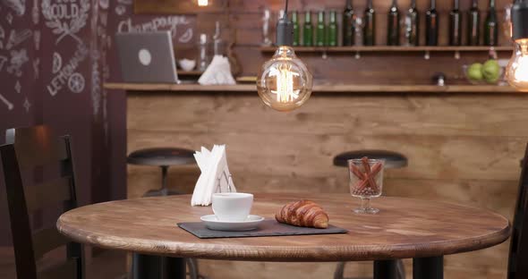 Minimalist Composition of a Cup of Coffee and a Croissant on a Dark Tray