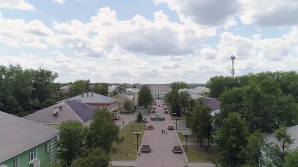 People walks along a beautiful alley in a provincial town. Aerial 01