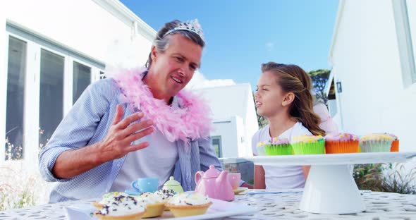 Smiling father and daughter in fairy costume having a tea party 4k