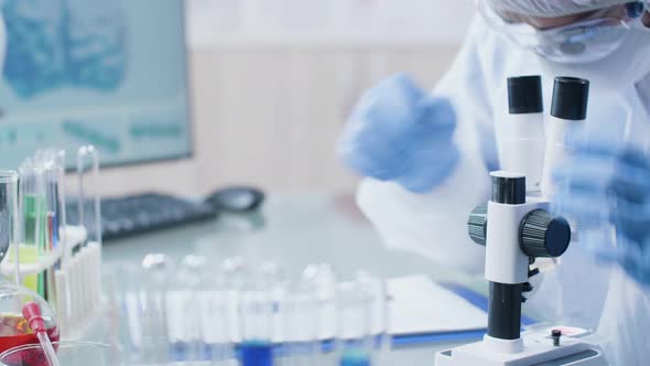 Close Up Dolly Footage of Laboratory Technician Looking Into the Microscope alt