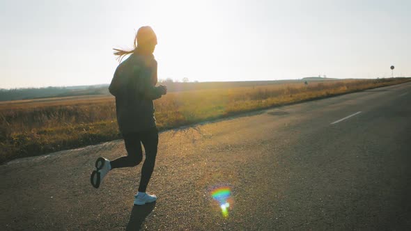 Silhouette Fitness Sport Women Running on Road at Sunset