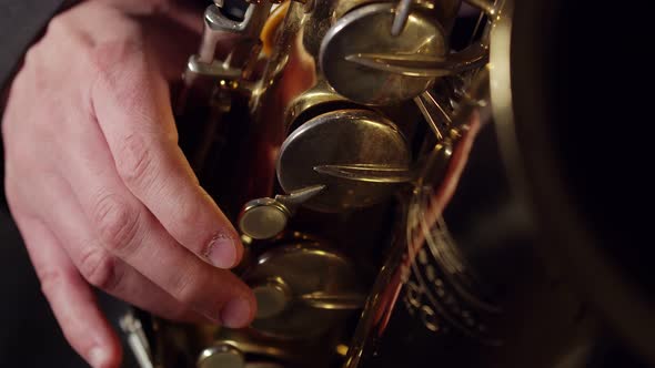 Artist Presses the Saxophone Valves with Fingers Closeup