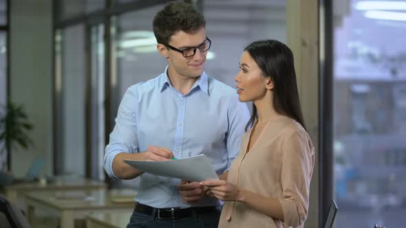 Male Accountant Discussing Costs With Female Director of Company Showing Papers