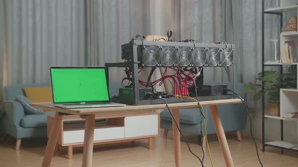 A Green Screen Laptop And Mining Rig On The Table For Mining Cryptocurrency