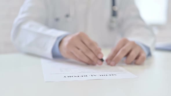 Close Up of Doctor Reading Medical Report