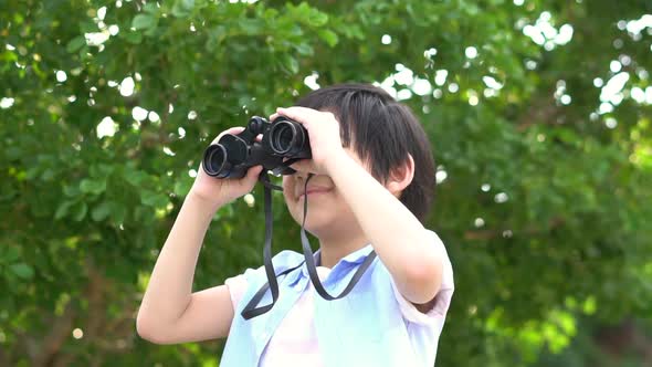 Cute Asian Child Using Binocular On Summer Day