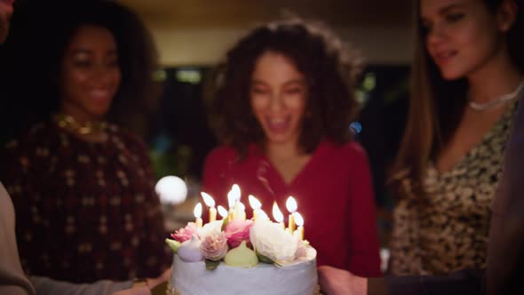 Friends Surprising Birthday Girl with Burning Candles Cake at Celebration Party