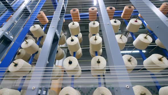 Many Clews Rotating While Coiling Threads at a Modern Textile Plant