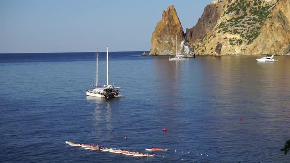 Group of Young Womens in Swimsuits Doing Yoga and Pilates on Sup Board in Calm Sea Early Morning