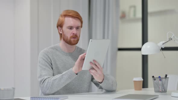 Successful Redhead Man Celebrating on Tablet at Work 