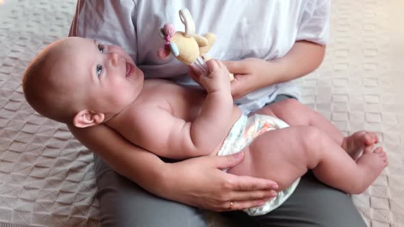 Mother Young Woman Holding Newborn Child and Playing with Him