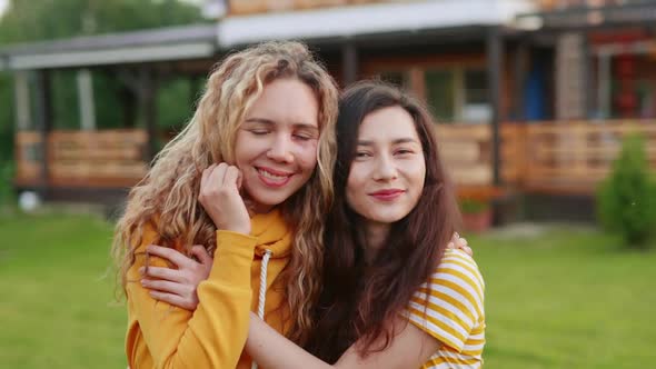 Portrait of Two Happy Women in Love. Asian Girl Kissing Her Girlfriend with a Scar on Her Face. Body