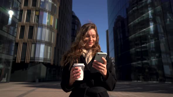 Young Business Woman With Coffee To Go Using Mobile Phone