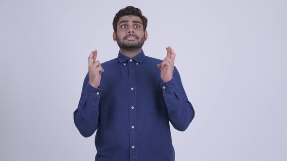 Young Bearded Indian Businessman Wishing with Fingers Crossed