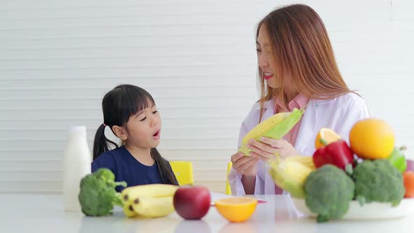 beautiful asian nutritionist Explain the benefits of food to a cute little girl.